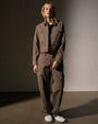 The model showcases a fashionable cashmere jacket paired with coordinating pants, exuding a chic look.