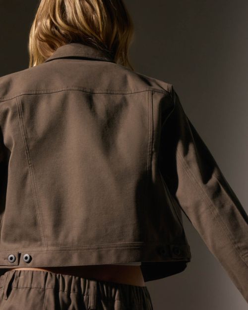 The back of a woman dressed in a cashmere jacket, highlighting the jacket's texture, style, and fit.