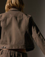 The back of a woman dressed in a cashmere jacket, highlighting the jacket's texture, style, and fit.