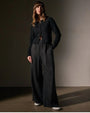  A model wearing a black sweater paired with lightweight linen wide-legged black pants.