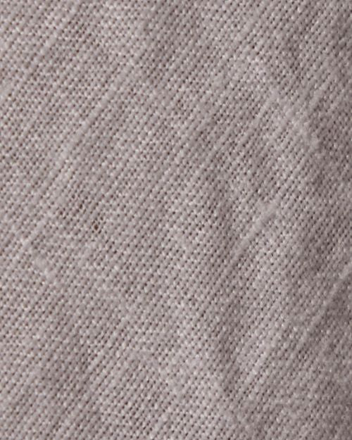 Close-up of a high-low linen skirt, showcasing its textured fabric with a soft, natural weave.