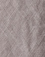 Close-up of a high-low linen skirt, showcasing its textured fabric with a soft, natural weave.