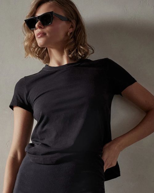 A model wearing a black crop tee shirt and sunglasses, showcasing a stylish summer look.