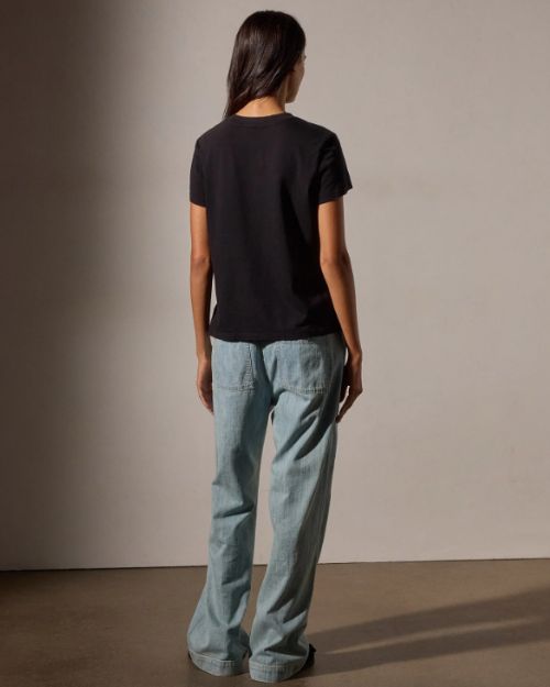 Back view of a woman in jeans and a black crop tee shirt, showcasing a casual and stylish outfit.