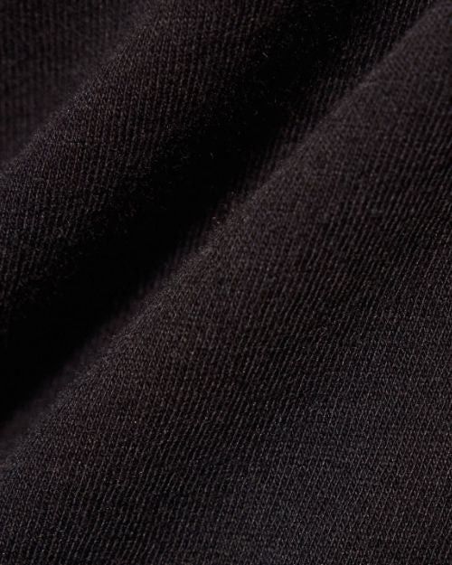  Close-up of a black fabric, showcasing the texture of a ladies' black crop tee shirt.