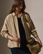 Model wearing a wool blend button-up shirt and a black skirt, posing against a neutral background.
