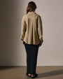 Back view of a woman in a long skirt and a wool blend button-up shirt, showcasing a stylish and casual outfit.
