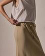  Model in a white tank top paired with a wool blend bias cut drawcord skirt.