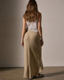 Back view of a woman in a wool blend bias cut drawcord skirt, showcasing its flowing design and elegant silhouette.