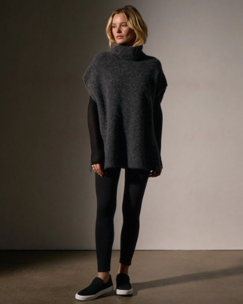 Model in a waffle knit funnel neck tunic and black leggings, showcasing a stylish and cozy outfit.
