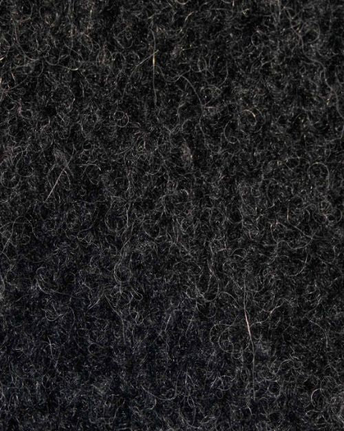 An up-close image of a waffle knit funnel neck tunic.  with dense black fibers, showcasing its rich texture and design.
