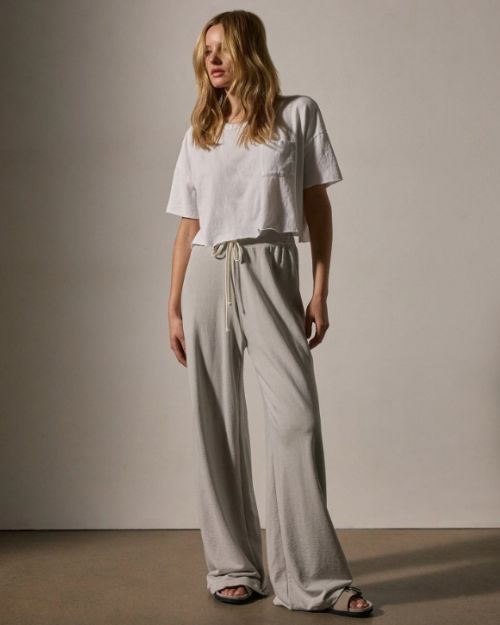 A model wearing a white t-shirt paired with wide-leg sweatpants, showcasing a casual and comfortable outfit.