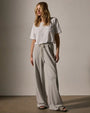 A model wearing a white t-shirt paired with wide-leg sweatpants, showcasing a casual and comfortable outfit.