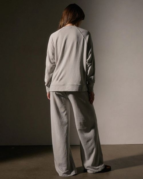 A back view of a Model wearing a vintage French Terry sweatshirt and wide-legged pants, showcasing a relaxed and stylish look.
