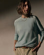 A woman dressed in a fresco boyfriend raglan sweatshirt and khaki pants poses for the image.