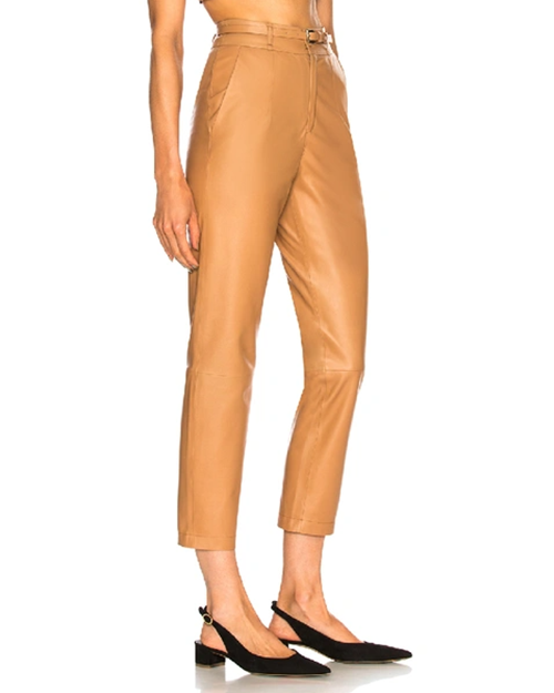 Model wearing Mom Leather Pants in camel tan with black short heel.
