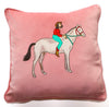 Peach colored cushion cover with embroidered cowgirl riding horse. 
