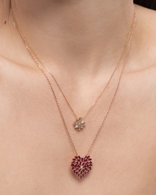 Model wearing Medium Ruby Heart Necklace with smaller neck with flower pendant.
