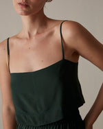 Model wearing dark green Fabia Top in front of tan/neutral background. 