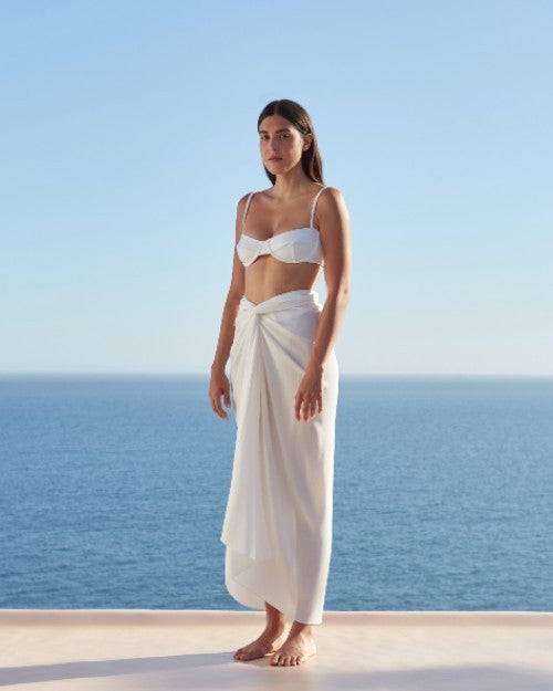 Model wearing Panneaux Cover-Up in Off White in front of ocean backdrop.