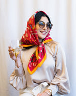 Model wearing 12 Days of Christmas Silk Berry Scarf around head while sipping from wine glass.