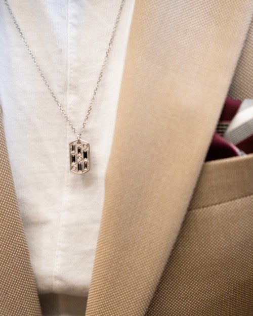 Man wearing Inlay Dog Tag Pendant Necklace with tan suit jacket and white tee.