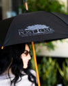 Woman holding The Post Oak Umbrella in black while outside.