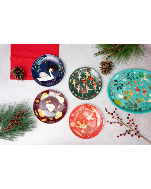 Karen Mabon holiday plates placed on holiday decorated white table.