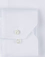 White fabric including a pocket with two clear buttons. 