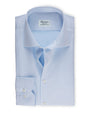 An overhead view of a folded light-blue button-down shirt with a chest pocket including two buttons. The shirt has a white square label inside the collar that reads "Stenströms" in cursive. The background is white.