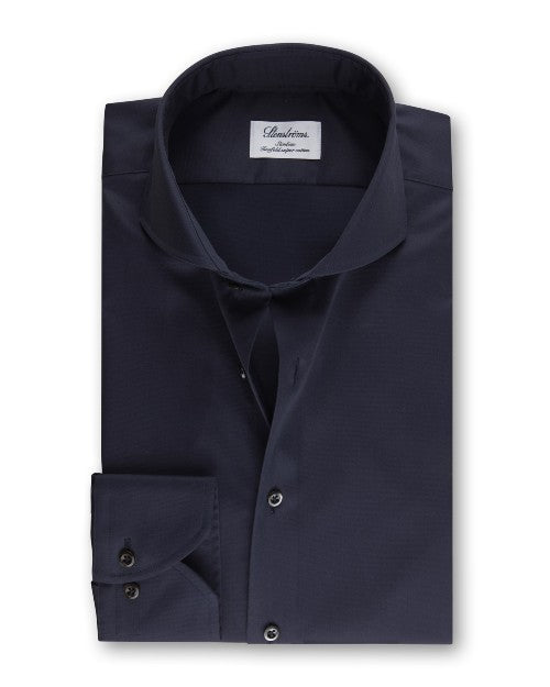 An overhead view of a folded navy button-down shirt with a chest pocket including two buttons. The shirt has a white square label inside the collar that reads "Stenströms" in cursive. The background is white.