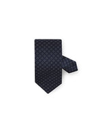 Patterned Silk Tie in navy in front of white background. 