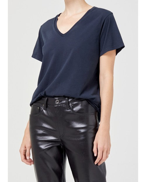 Model wearing navy blue deep neck tshirt with black leather pants. 