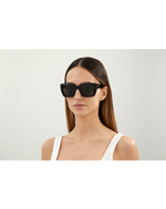 Model wearing Bottega Veneta New Classic Woman Sunglasses in front of white background.