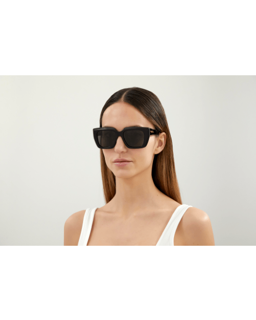 Model wearing Bottega Veneta New Classic Woman Sunglasses in front of white background.