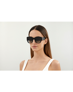 Model wearing C de Cartier Woman's Sunglasses in front of white background.