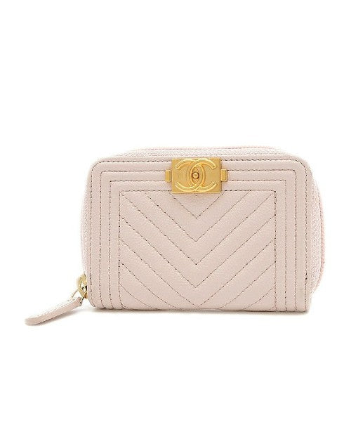 Pink coin case with gold hardware and clasp that has Chanel logo.