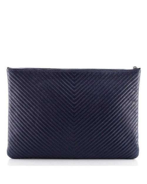 Chanel O Case Clutch Chevron Caviar Large in front of white background. 