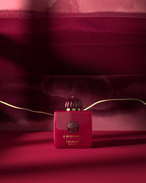 Amouage Crimson Rock bottle in front of ombre hot pink background. 