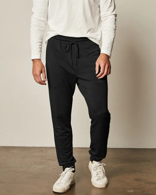 Model wearing Crosby Jogger in black with white sweater and shoes.