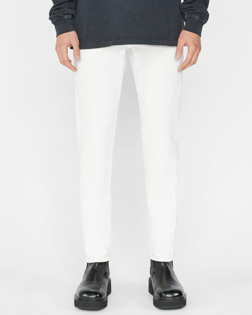Model wearing white jeans with grey sweater and black boots in front of white background.