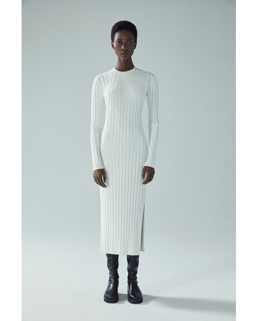 Model wearing Ribbed Sweater Dress in Off White in front of white background.