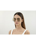 Model wearing Gucci Logo Woman Sunglasses in front of white background.