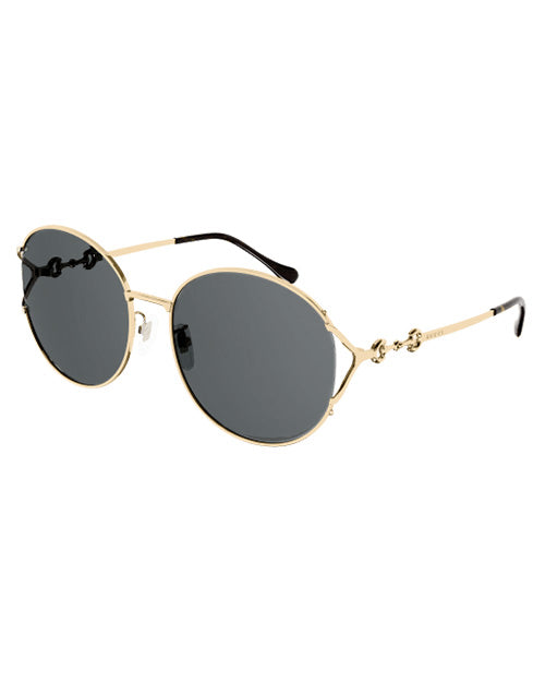 Gucci Logo Woman Sunglasses in gold and black in front of white background.