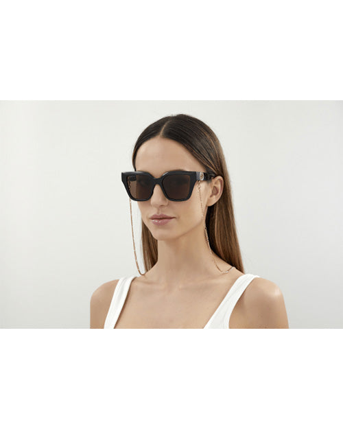 Model wearing Gucci Chain Woman Sunglasses in front of white background. 