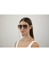 Model wearing Gucci Chain Woman Sunglasses in front of white background. 