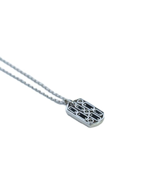 Close up of dog tag pendant with black sapphires and diamonds. 