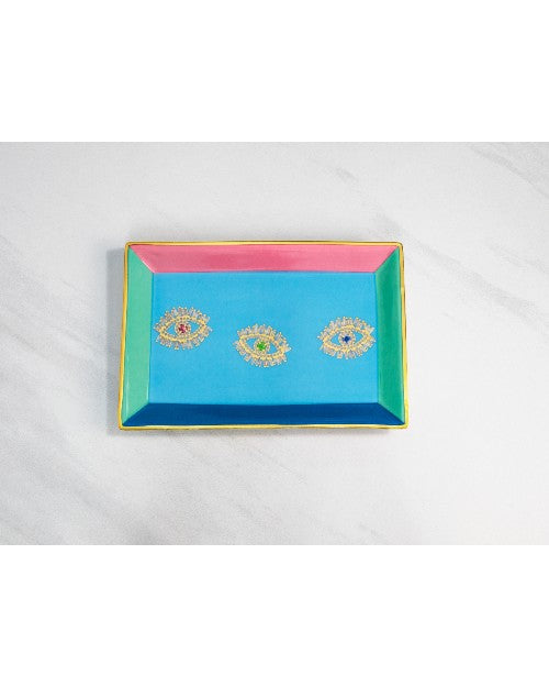 Multicolored jewelry tray with 3 evil eyes on marble surface.