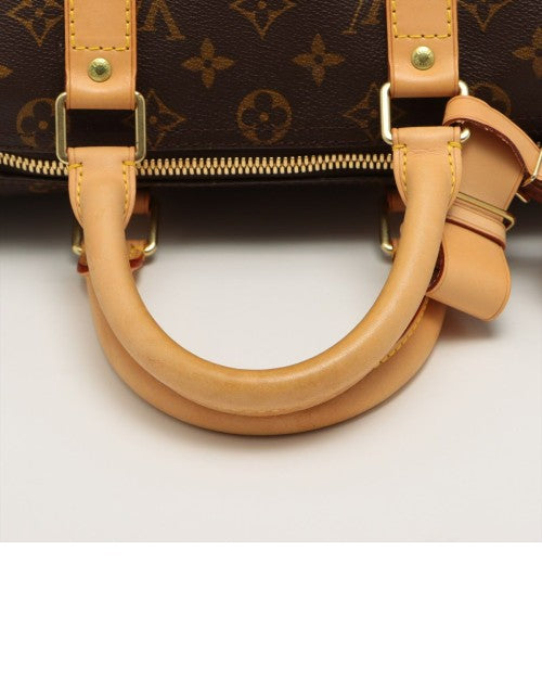 Tan handles on bag and gold zipper.