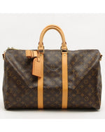 Dark brown Louis Vuitton bag with iconic pattern, tan handle with matching tag, and gold hardware.